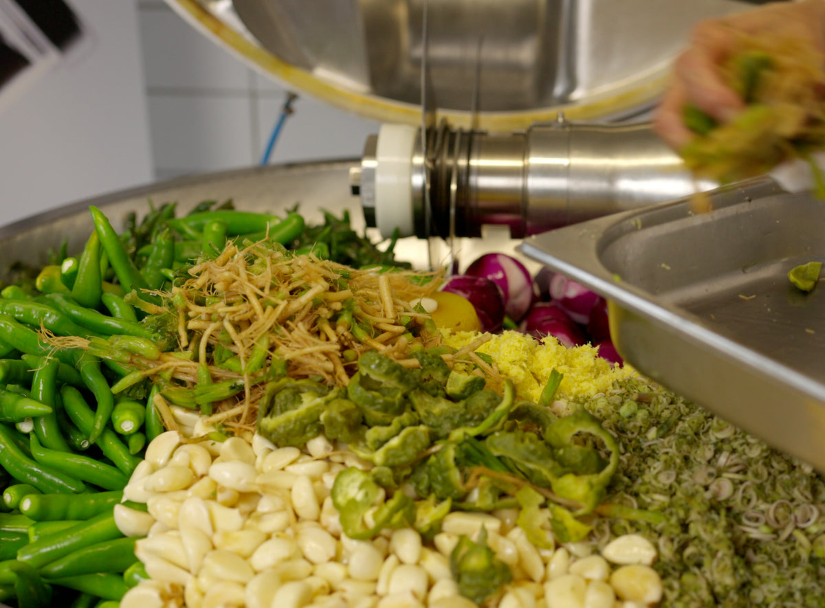 Frische Zutaten im Kessel: grüne Chilis, Knoblauch, Zitronengras und rote Zwiebeln