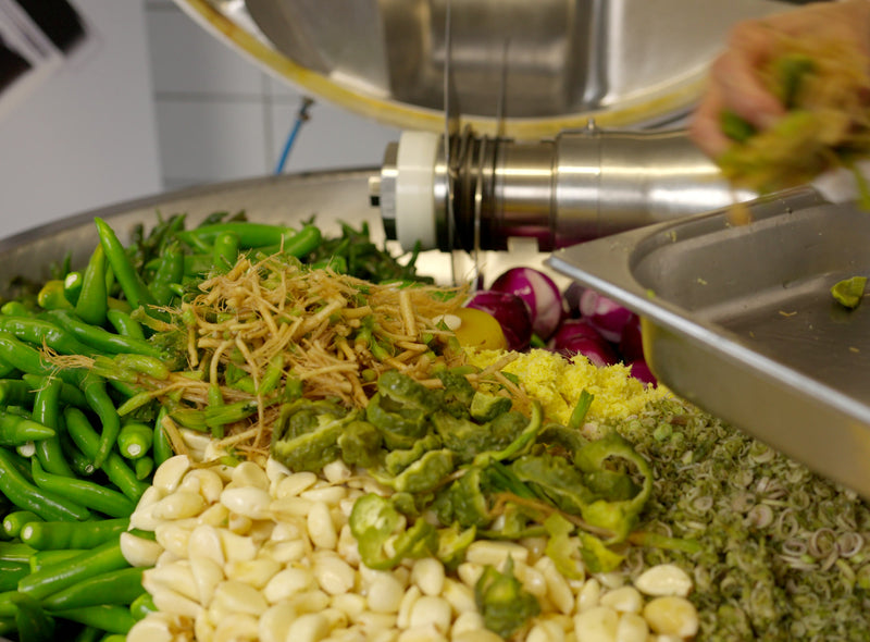 Frische Zutaten im Kessel: grüne Chilis, Knoblauch, Zitronengras und rote Zwiebeln