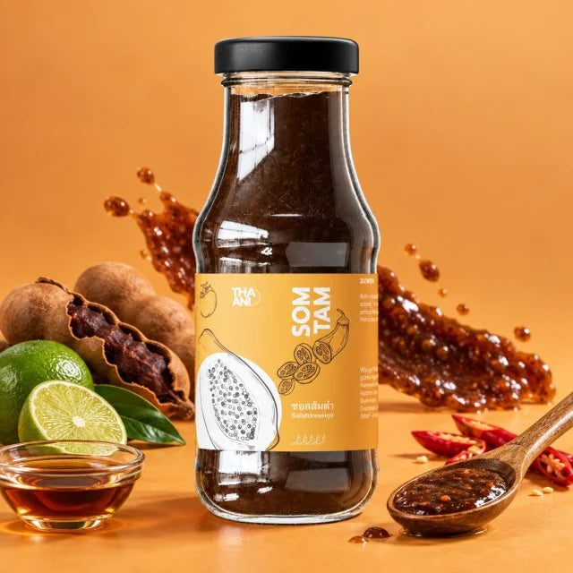 Som Tam — Salatdressing vor farbigem Hintergrund